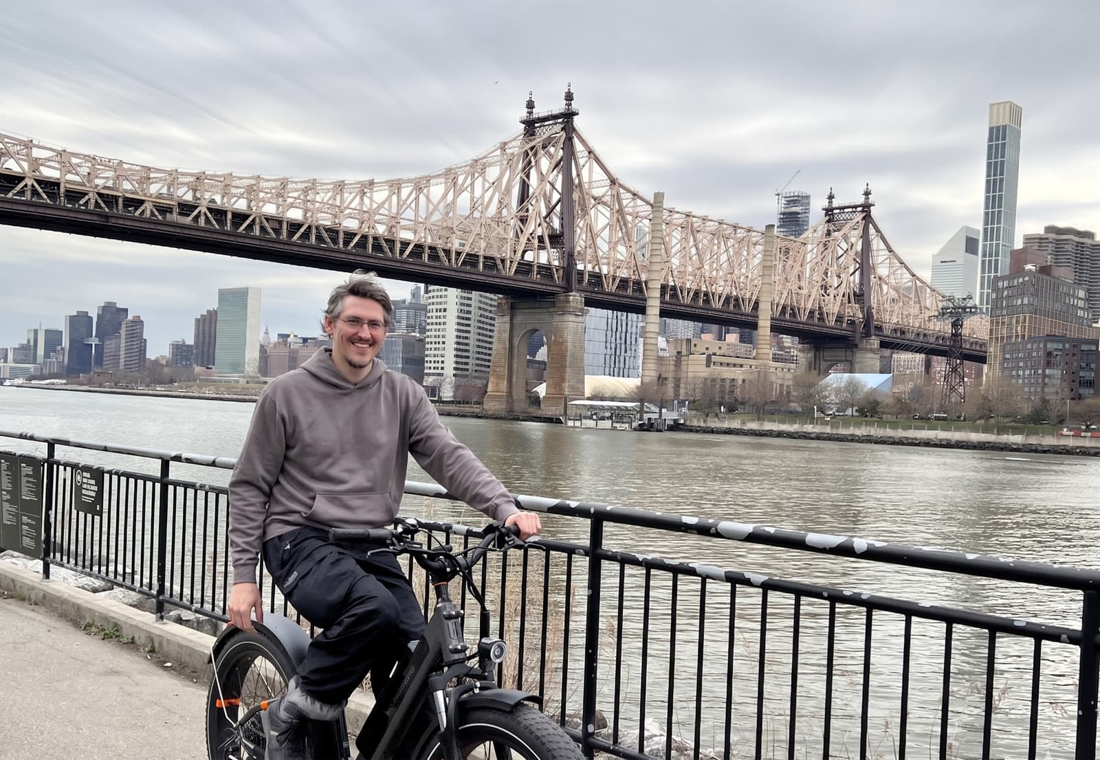 Cyclist carrying a Freshly Baked delivery through a rainy city street